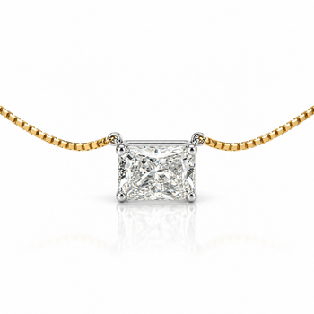A radiant-cut diamond pendant necklace on a gold chain, featuring a brilliant-cut diamond set in a silver-colored prong setting, shown against a white background with a soft reflection. – Assay Jewelers